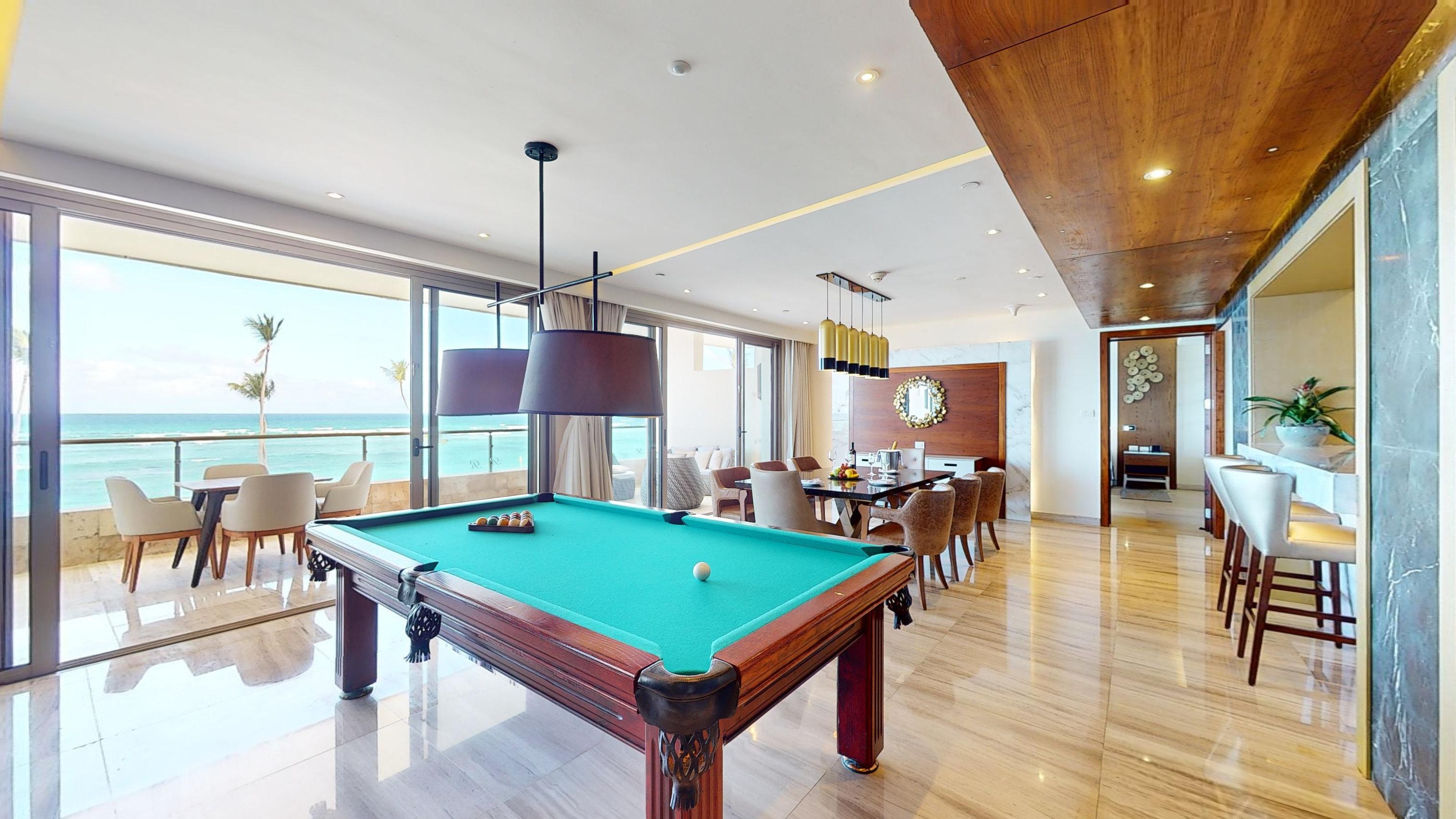 a pool table in a room with a view of the ocean