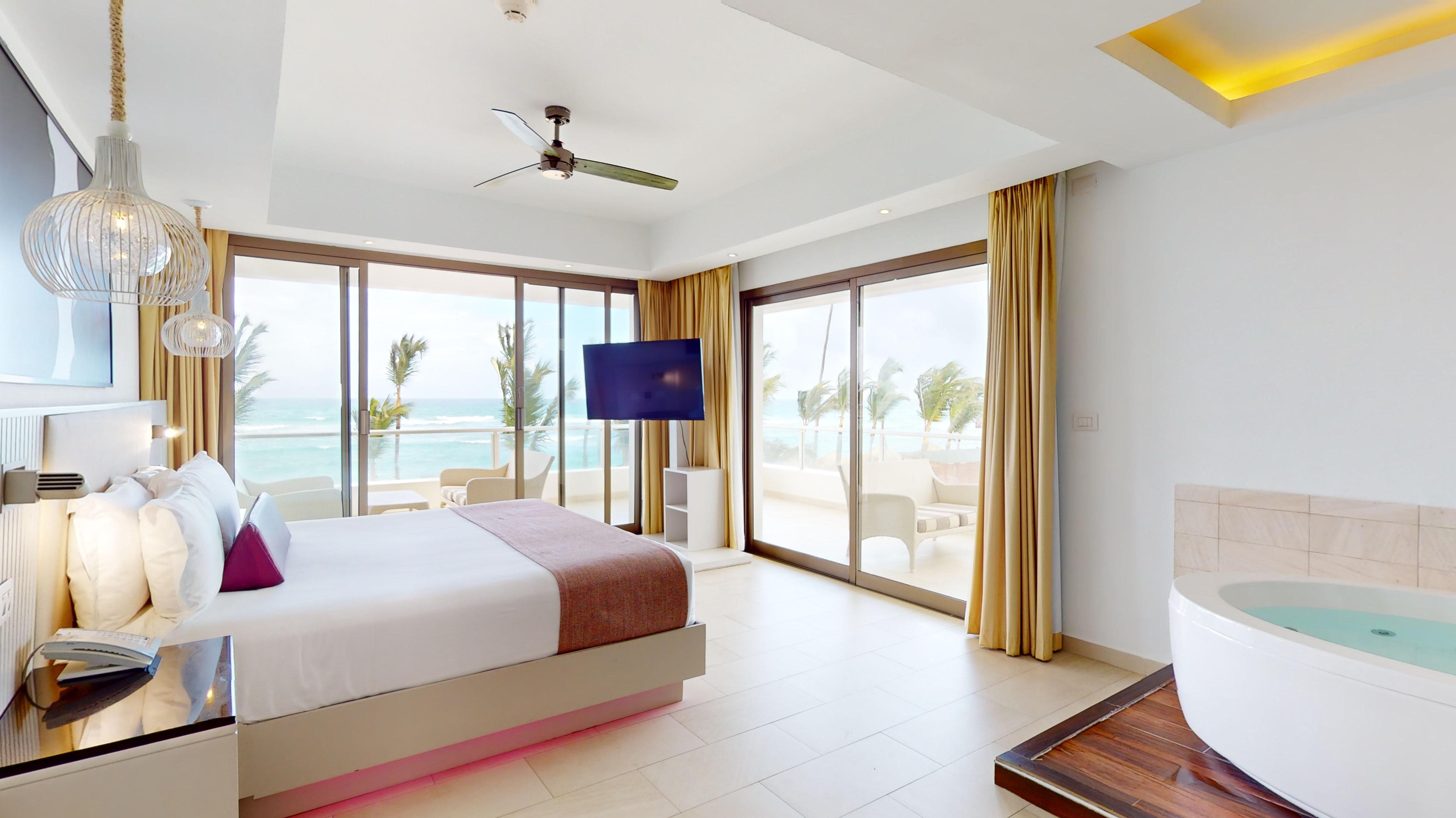 a bedroom with a television and a view of the ocean
