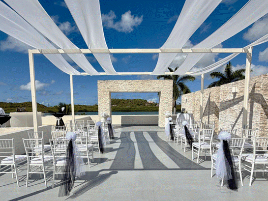 a white canopy with white chairs and black bows