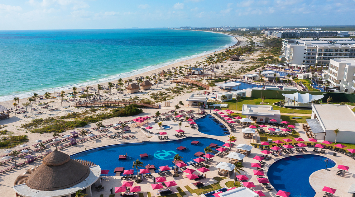 a beach with a pool and umbrellas