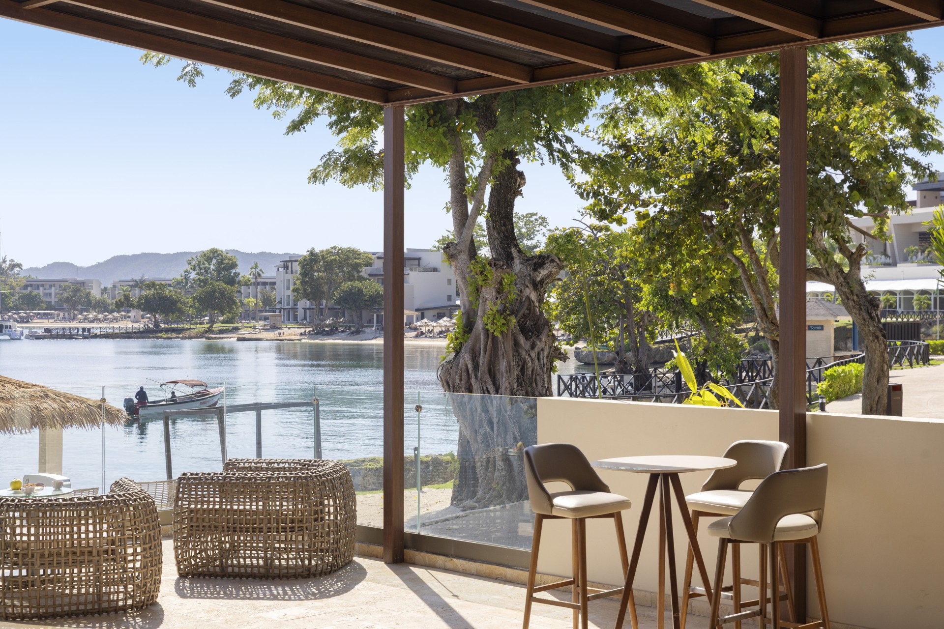 a patio with chairs and tables by a body of water