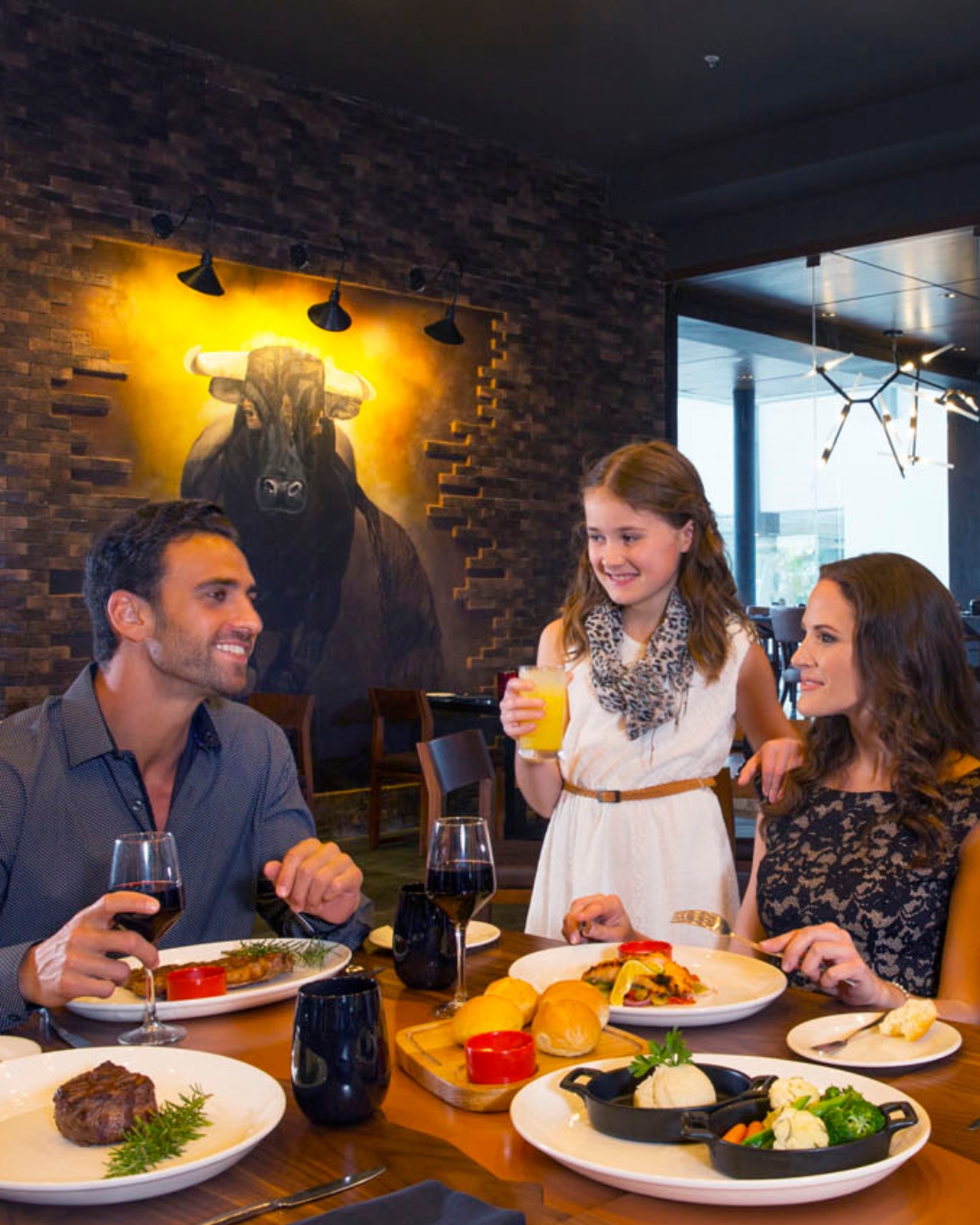 a group of people sitting at a table with food and drinks