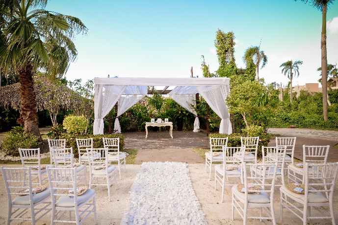 a white tent with white chairs and a table in the middle