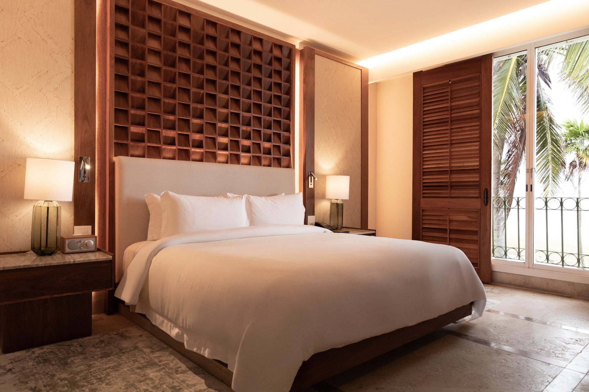 a bed with a white bedding and a wood paneled wall