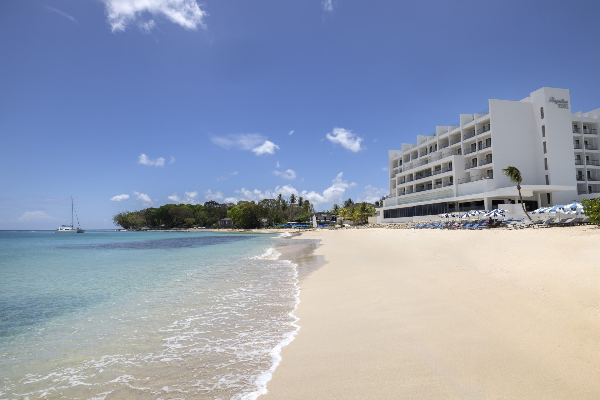 a beach with a building and chairs on it
