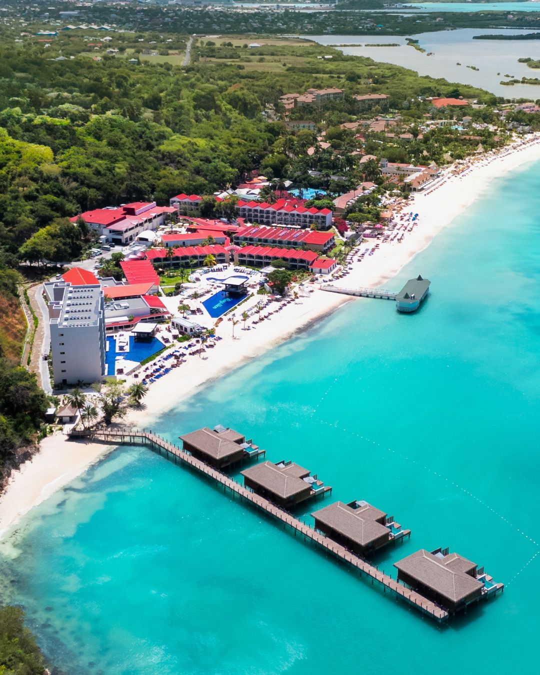 a beach with buildings and a dock