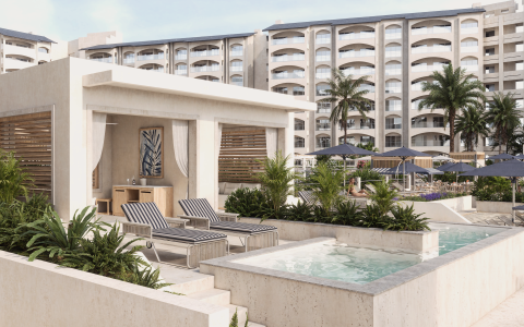 a pool with chairs and a hot tub in front of a building