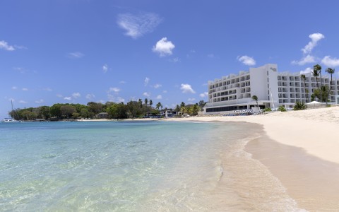 a beach with a building and a body of water