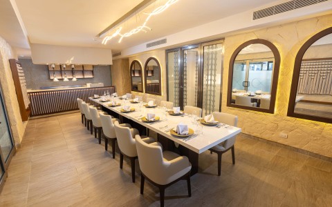 a long table with chairs and plates in a room