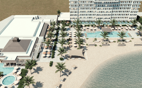 a building with palm trees and a pool on a beach