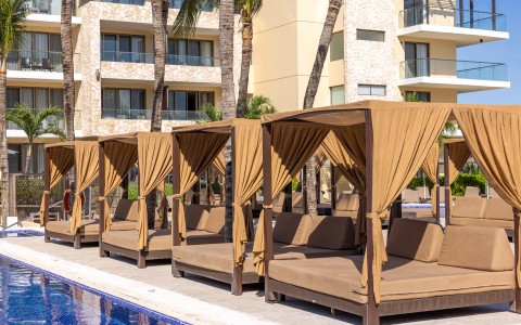 a group of beds next to a pool
