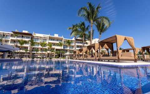 a pool with chairs and a building in the background