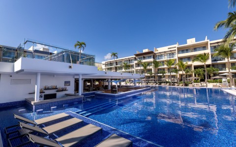 a pool with lounge chairs and a building in the background