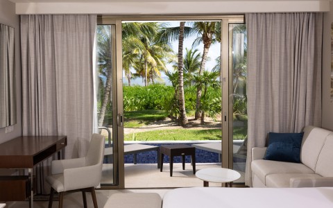a room with a view of palm trees and a pool
