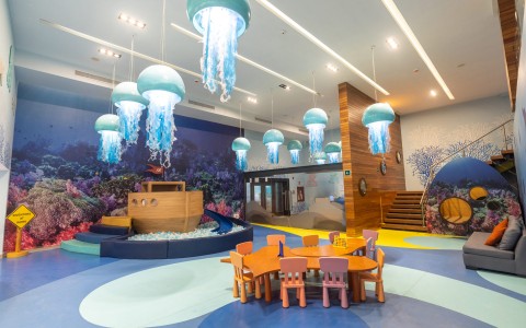 a room with a play area and a table and chairs