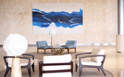 a room with chairs and a large painting