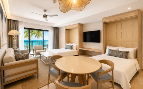 a room with two beds and a table and chairs