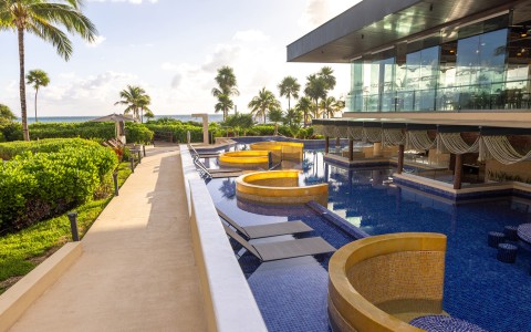 a pool with chairs and a building