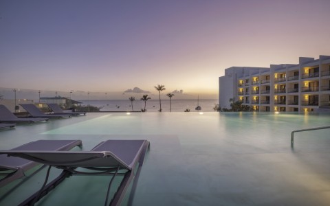 a pool with lounge chairs and a building in the background