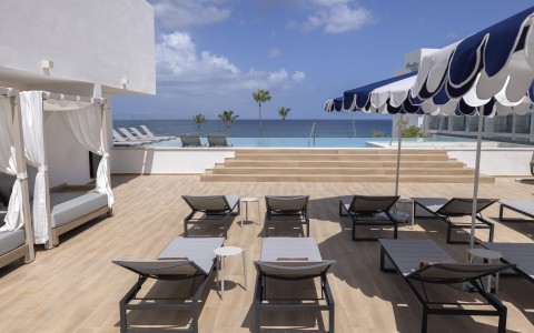 a deck with chairs and umbrellas on a sunny day