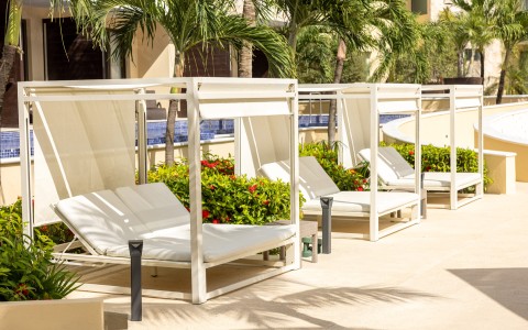 a group of white lounge chairs on a patio