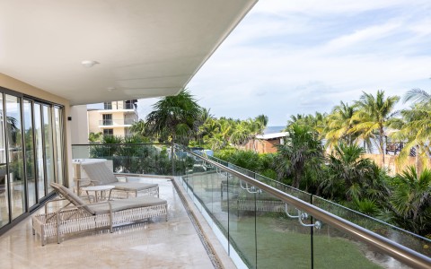 a deck with chairs and a glass railing