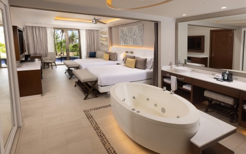 a room with a tub and two beds