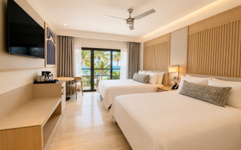 a room with two beds and a television