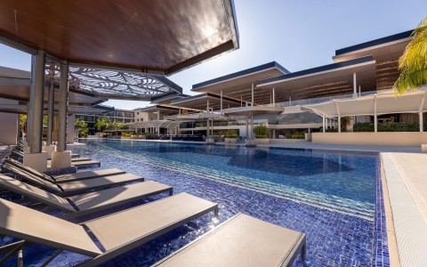 a pool with lounge chairs and a building
