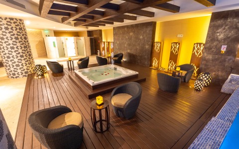 a room with a hot tub and chairs