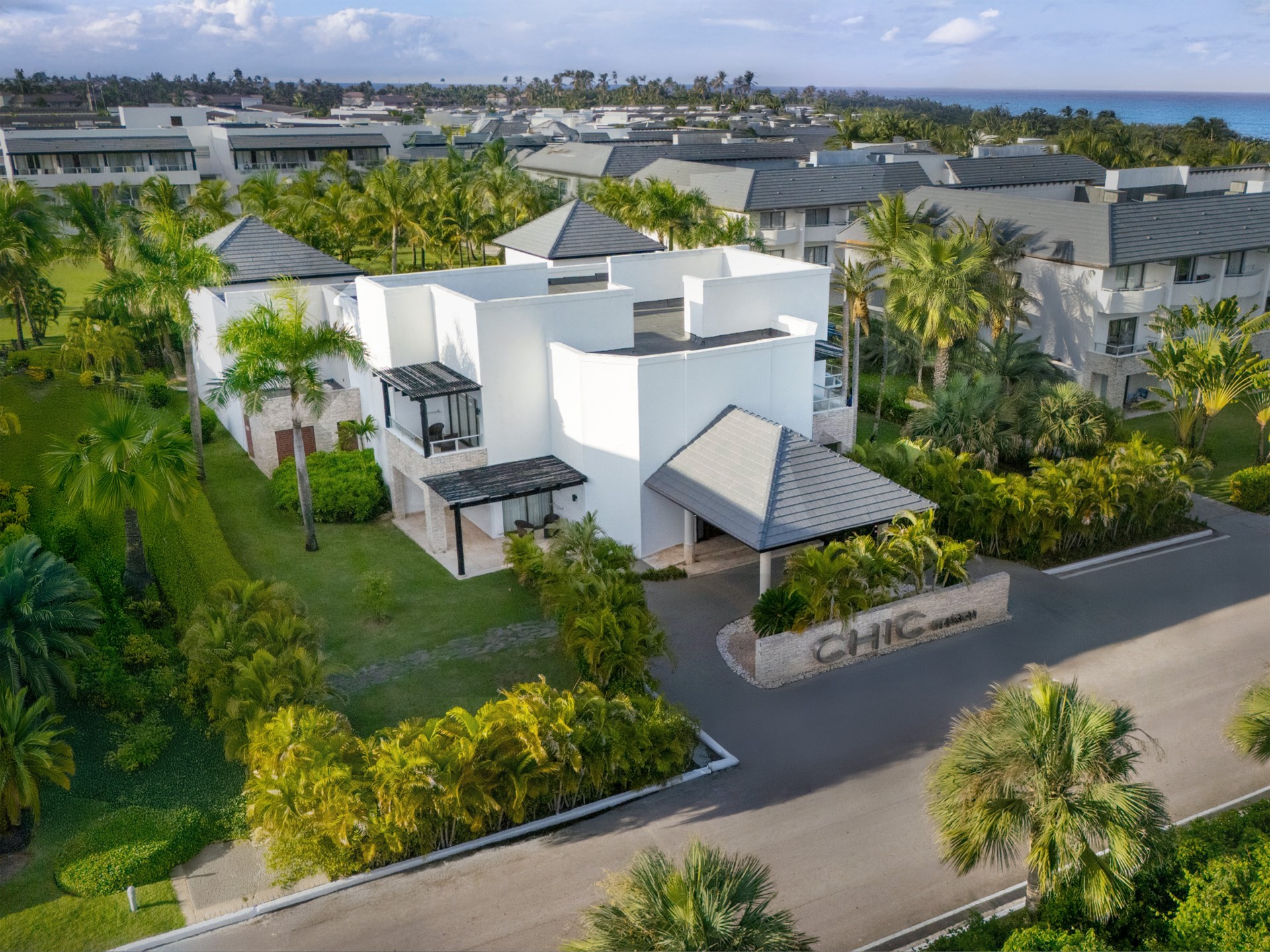 a white building with trees and a road