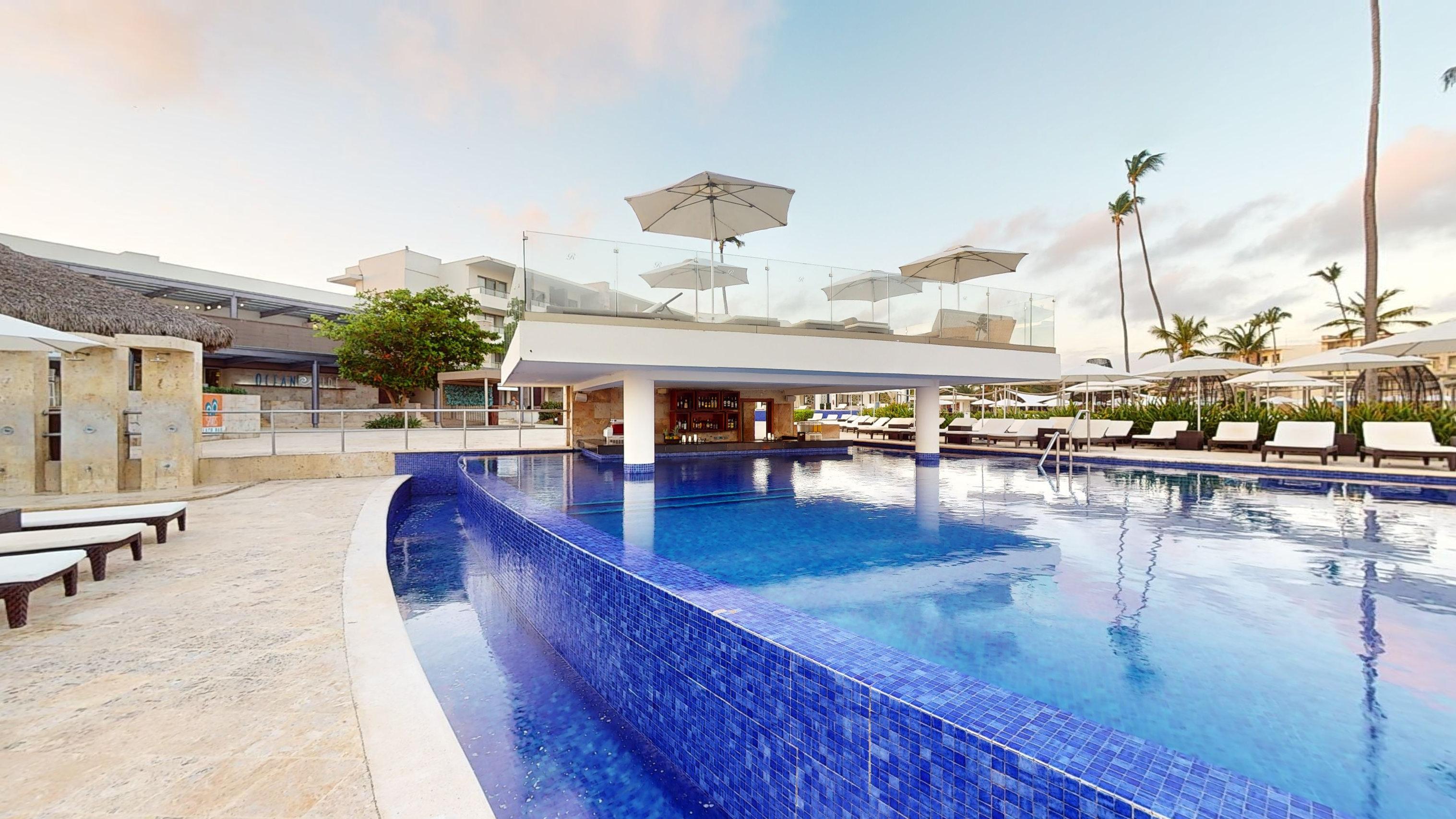 a pool with umbrellas and a building