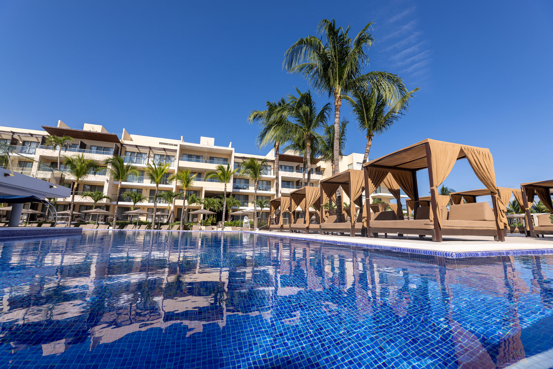 a pool with chairs and a building in the background