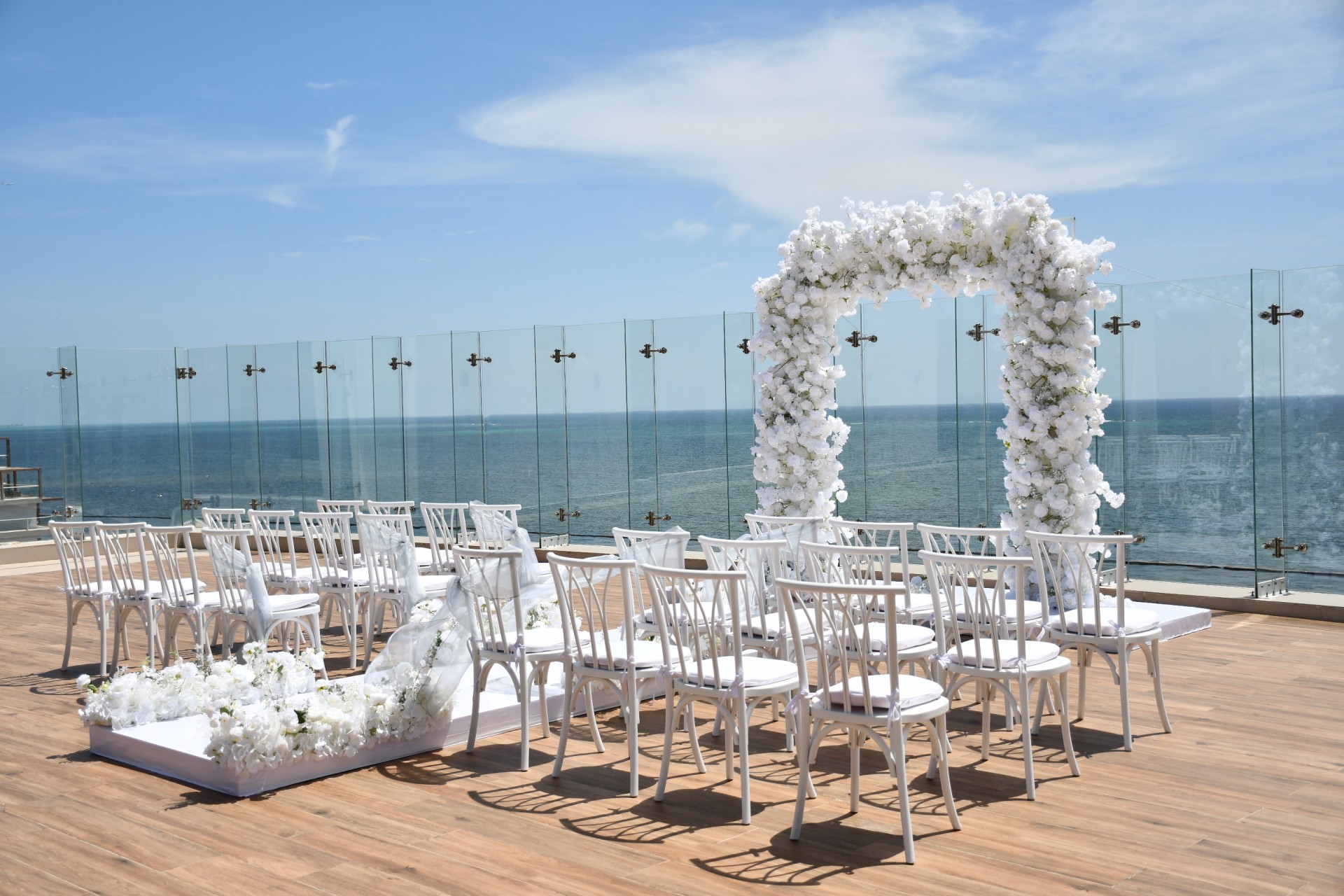 a wedding set up on a deck with chairs and flowers