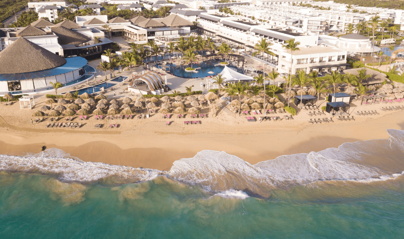 a beach with a swimming pool and a large building