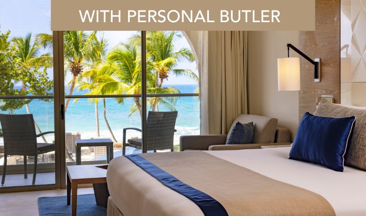 a room with a bed and chairs and a window with palm trees