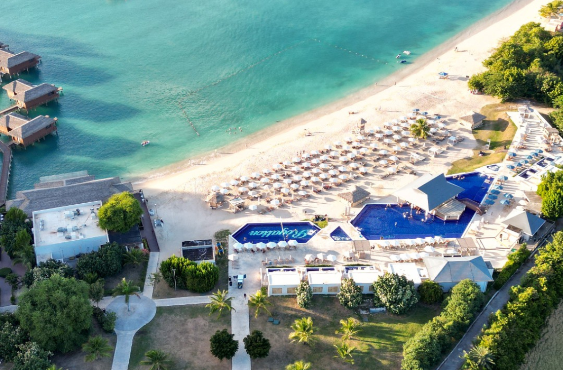 a beach with umbrellas and a pool