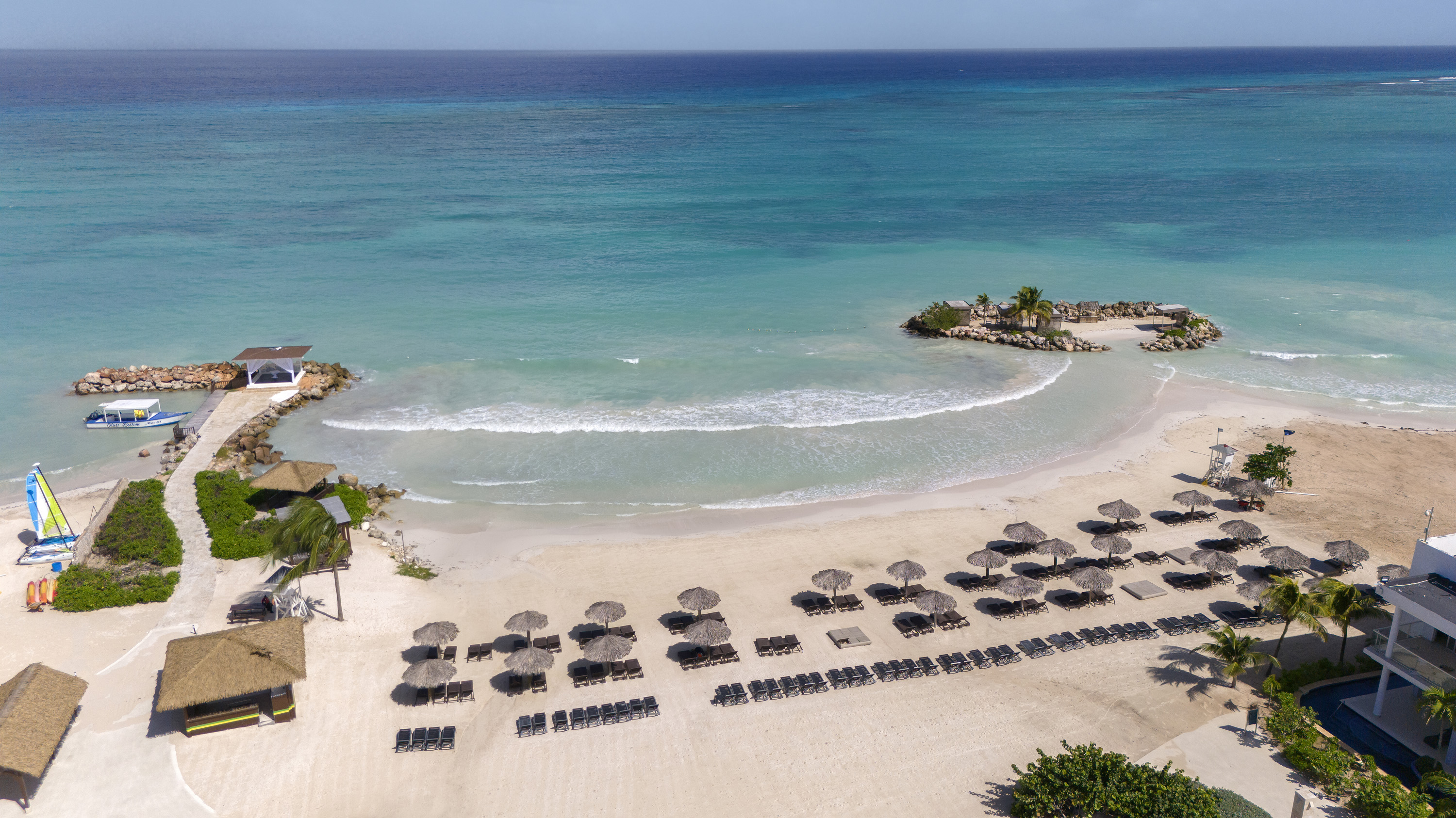 a beach with many people and umbrellas