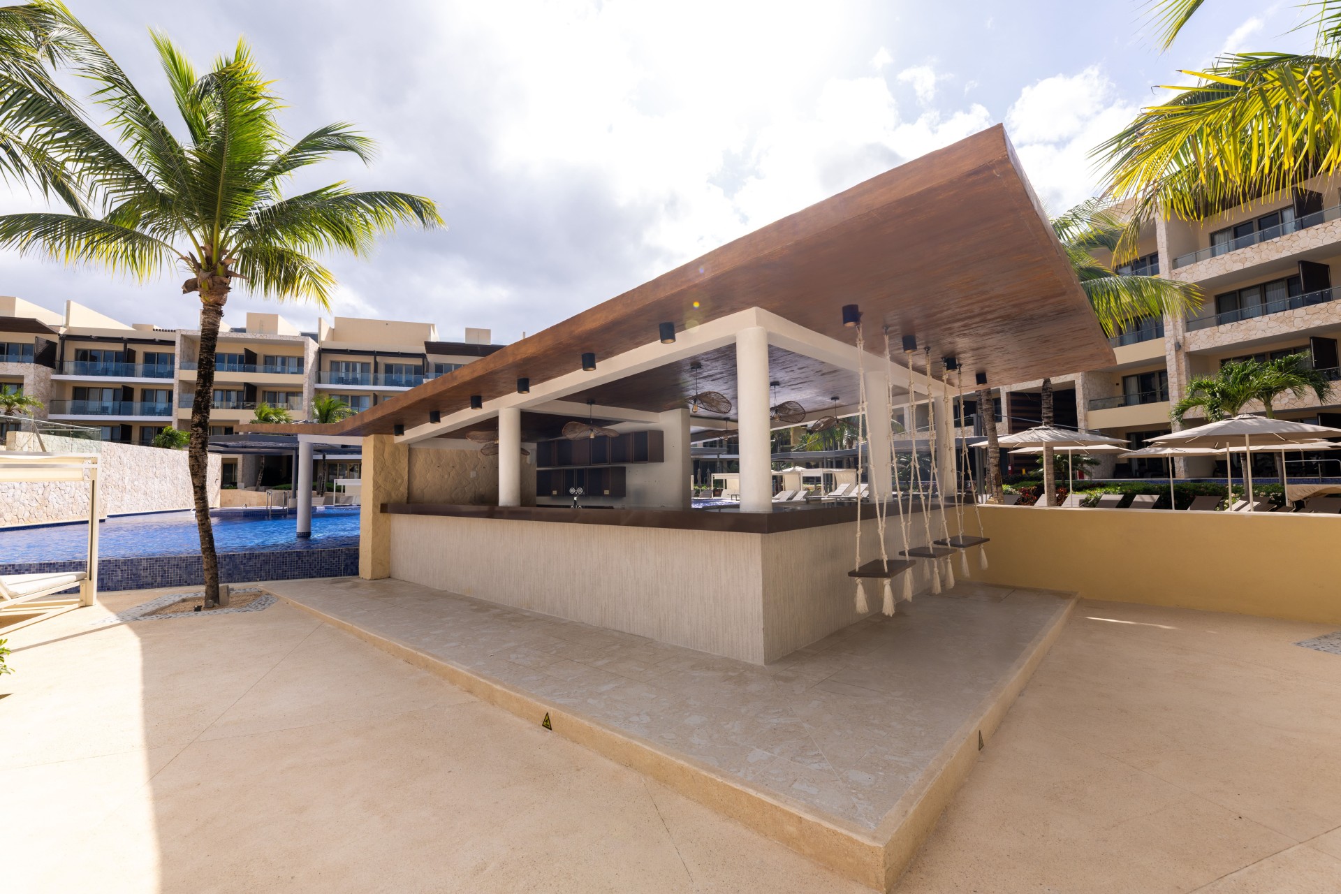 a bar with swings and a pool in the background