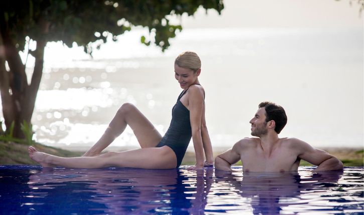 a man and woman sitting in a pool