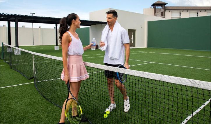 a man and woman standing on a tennis court