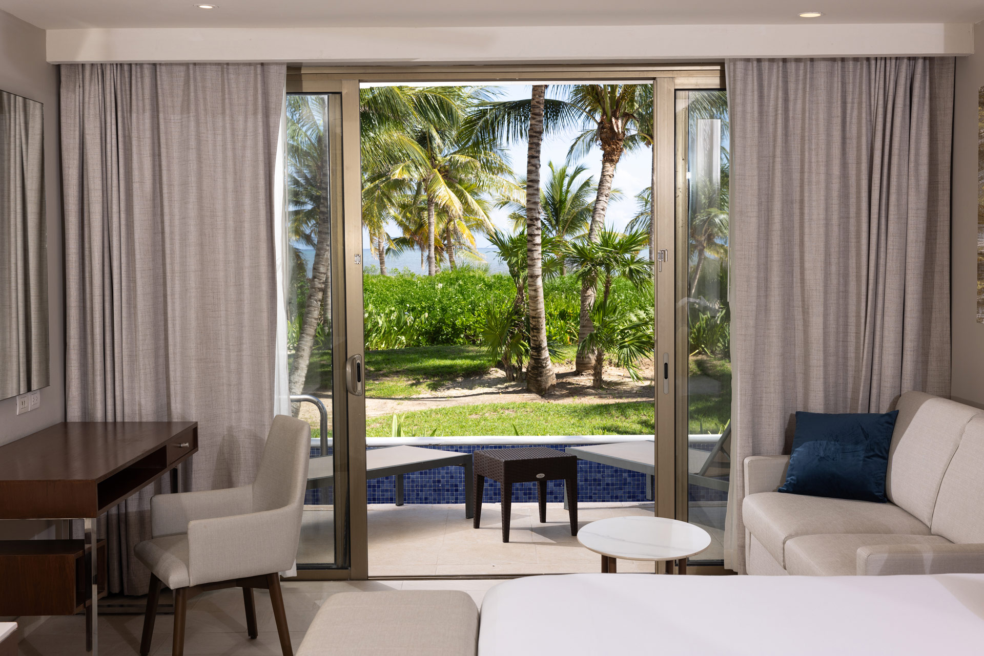 a room with a view of palm trees and a pool
