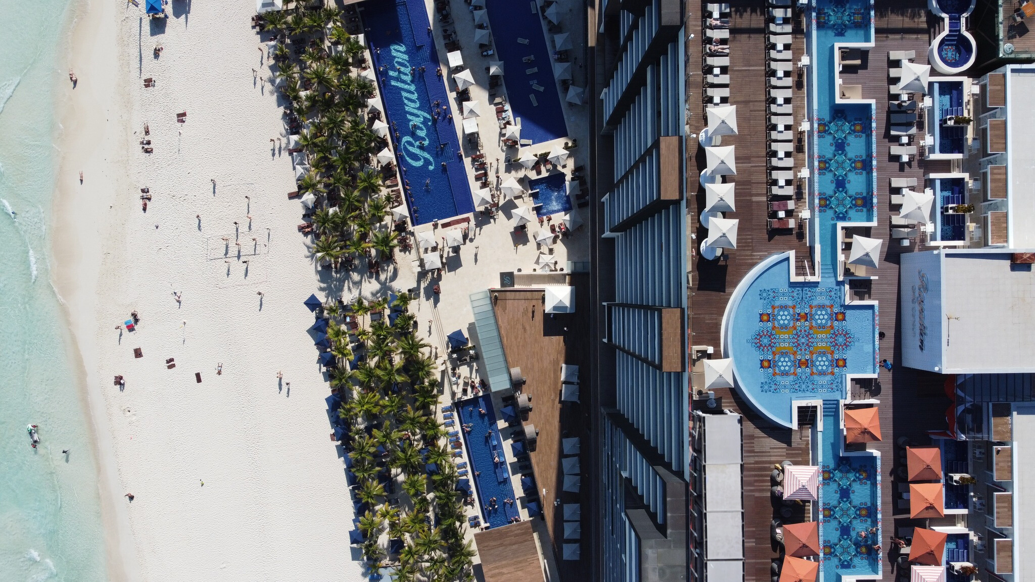 a beach with a pool and people on it