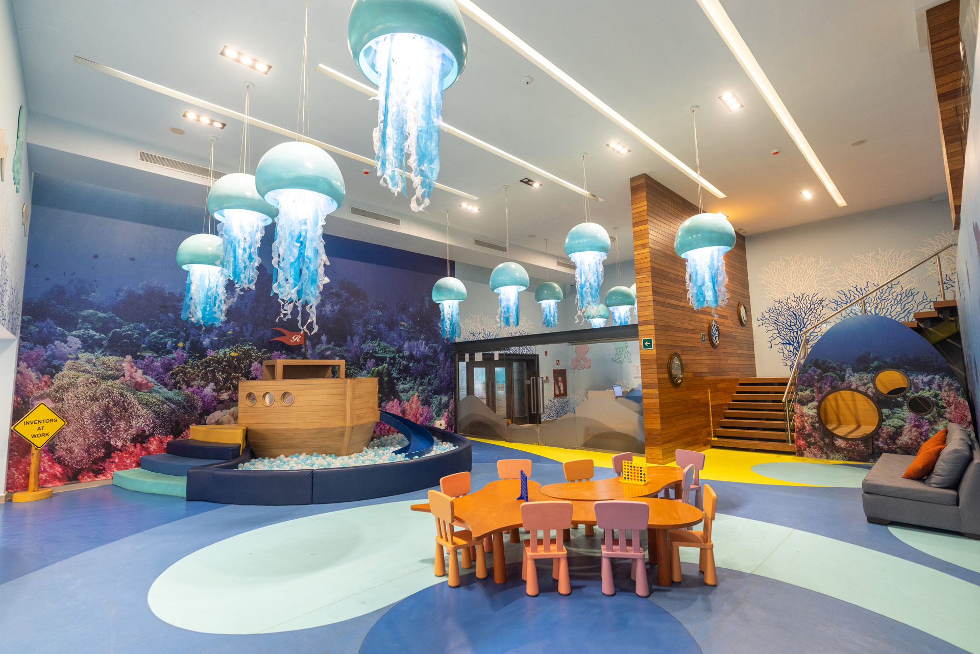 a room with a play area and a table and chairs