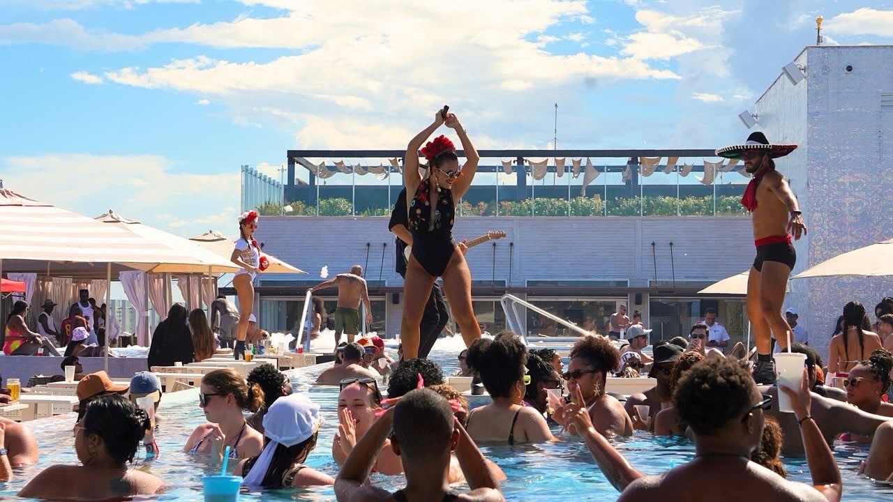 a woman in a black swimsuit dancing in a pool
