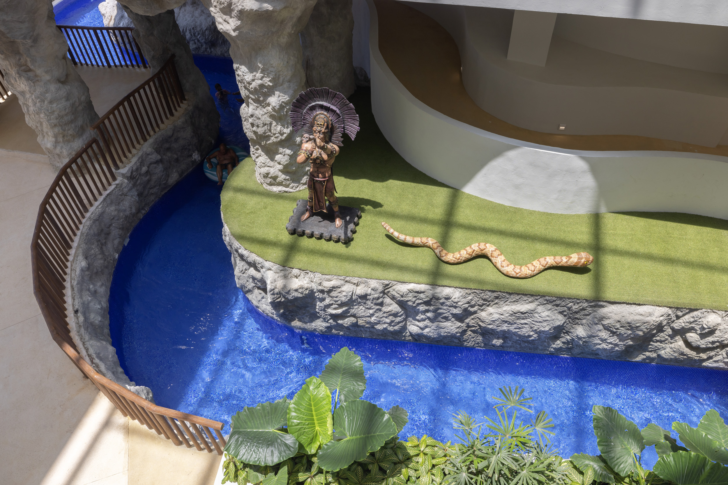 a statue of a man with a snake on a rock ledge