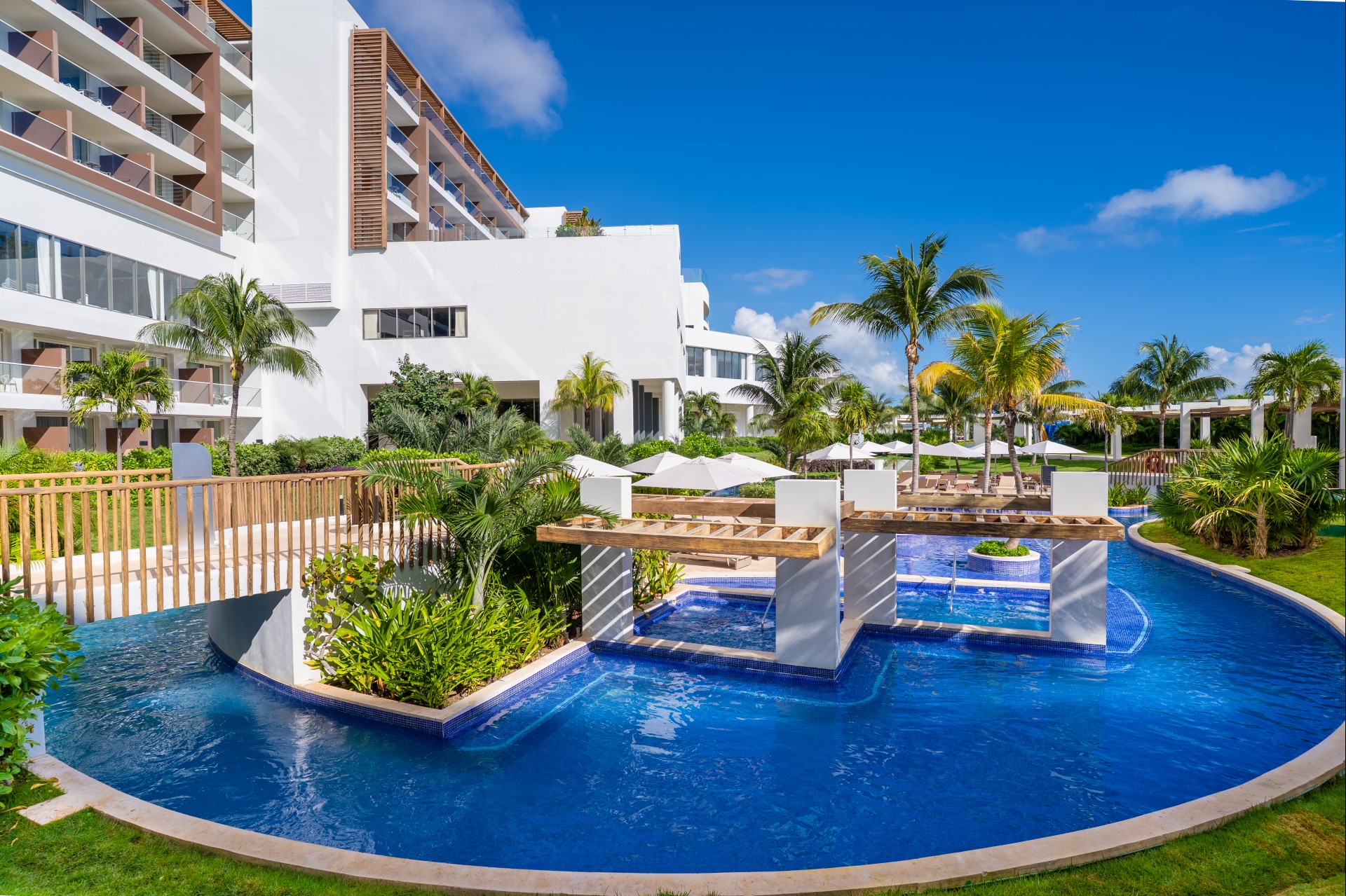 a pool with a bridge and palm trees in the background