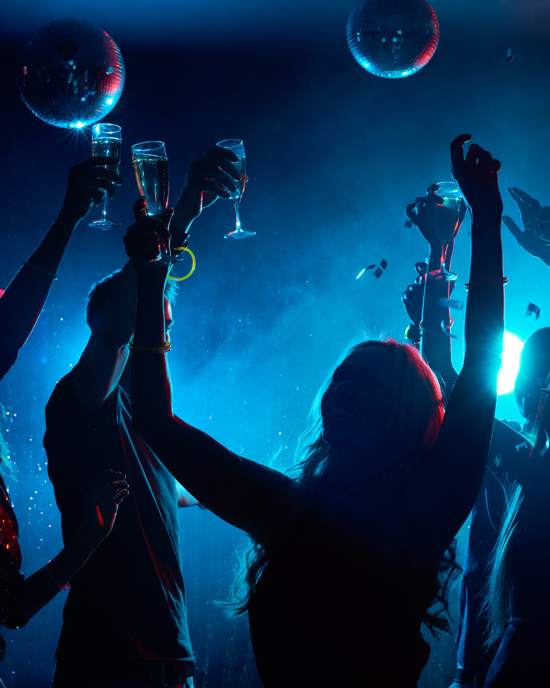 a group of people dancing with champagne glasses