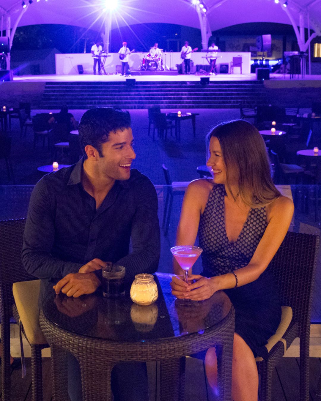 a man and woman sitting at a table with drinks