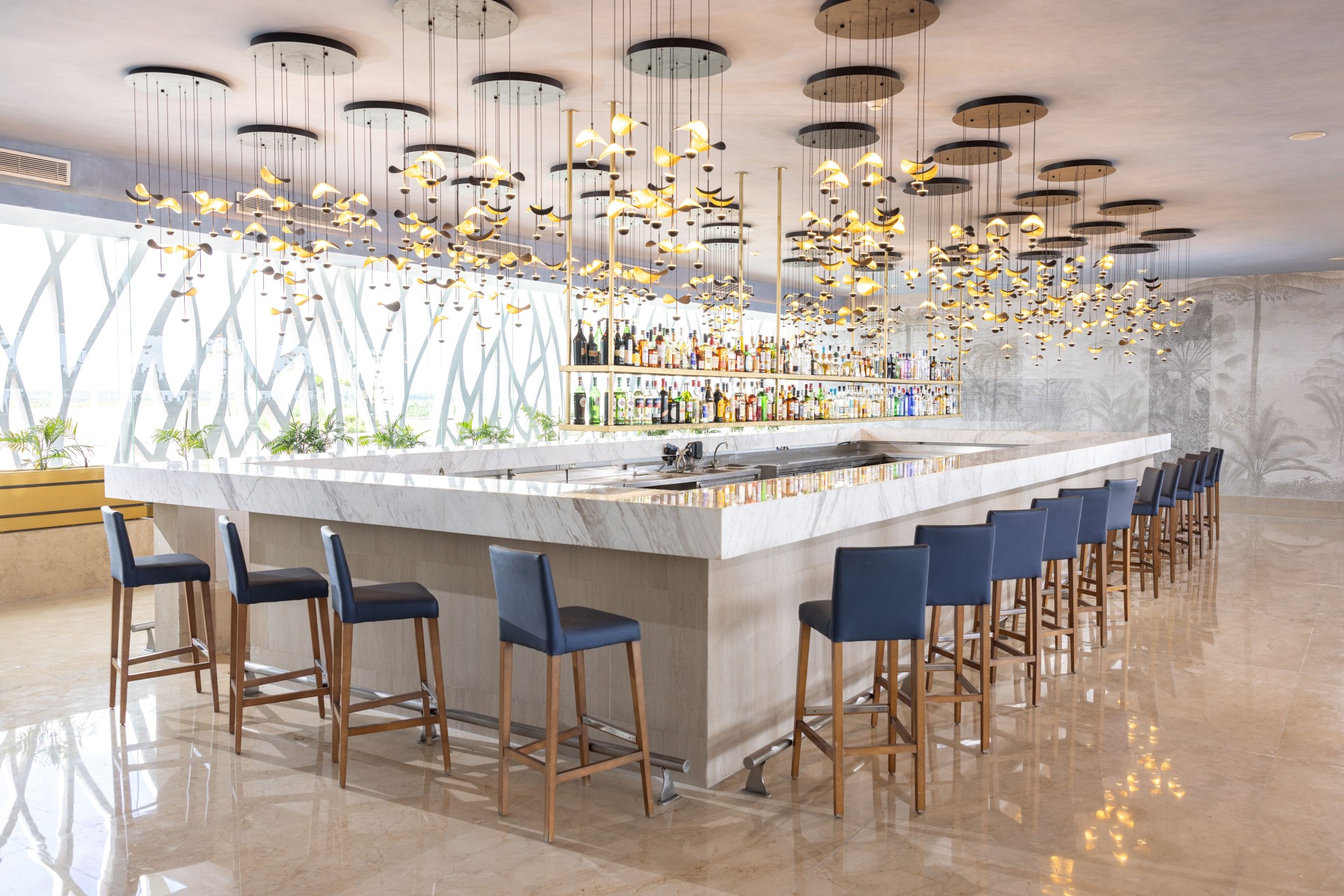 a bar with chairs and lights from the ceiling